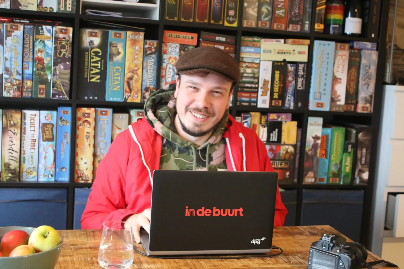 Melt Pels lachend achter een laptop met het logo van indebuurt